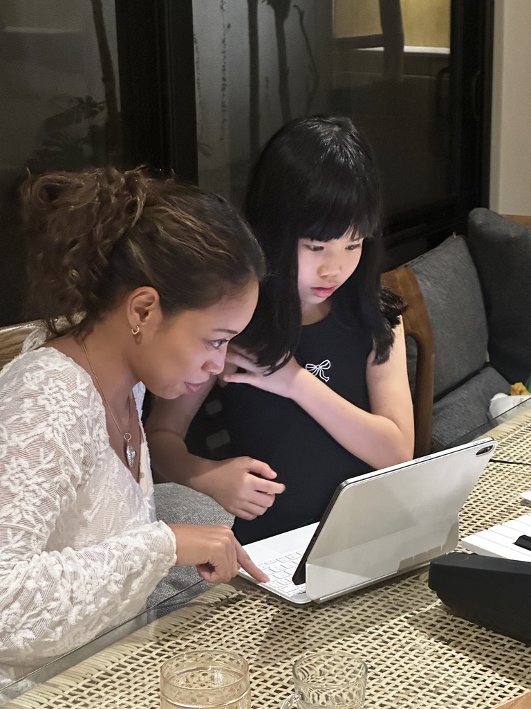 Deha helping a child learn at a table