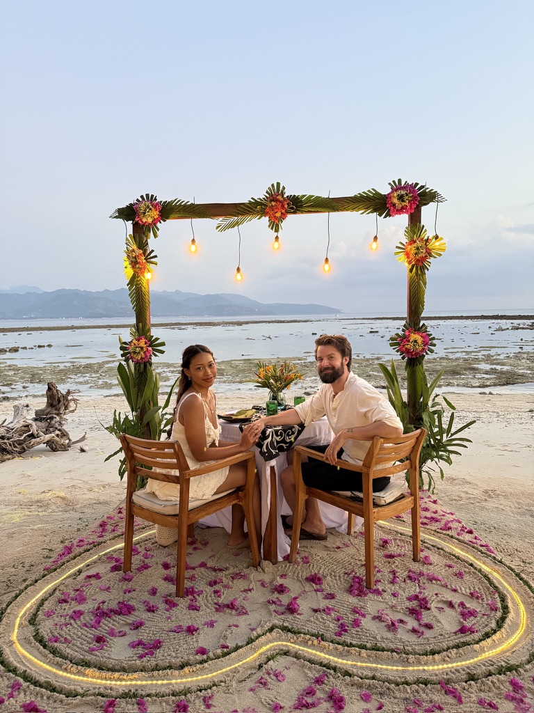 Michael and Deha having dinner beside the sea on their honeymoon