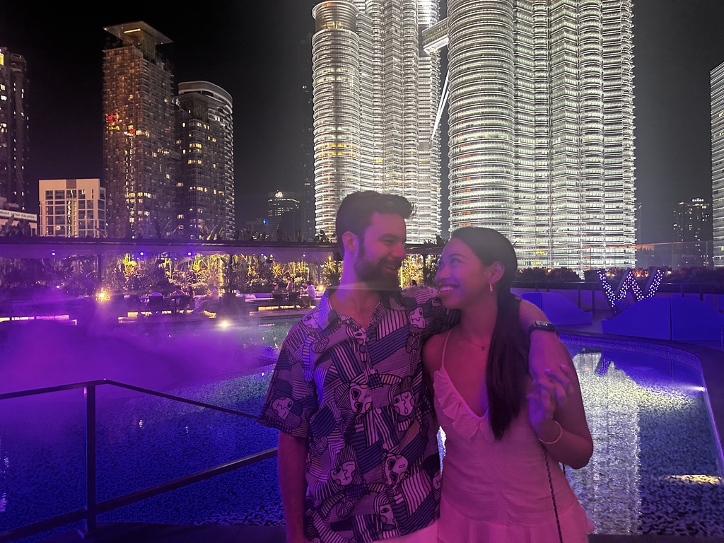 Michael and Deha taking a selfie with the Petronas Twin Towers at night