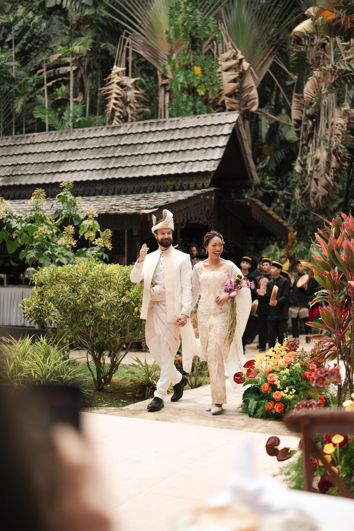 Michael and Deha walking through the garden during the Sanding procession